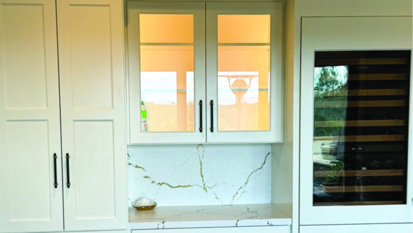 White built-in cabinetry with wine fridge, Cambria quarta countertops, in-cabinet lighting, and dark hardware