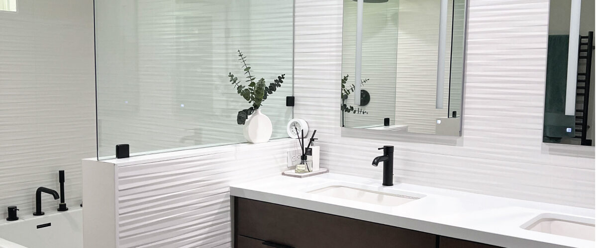 Master bathroom with white patterned tile on walls, white countertops, and dark wood toned cabinets