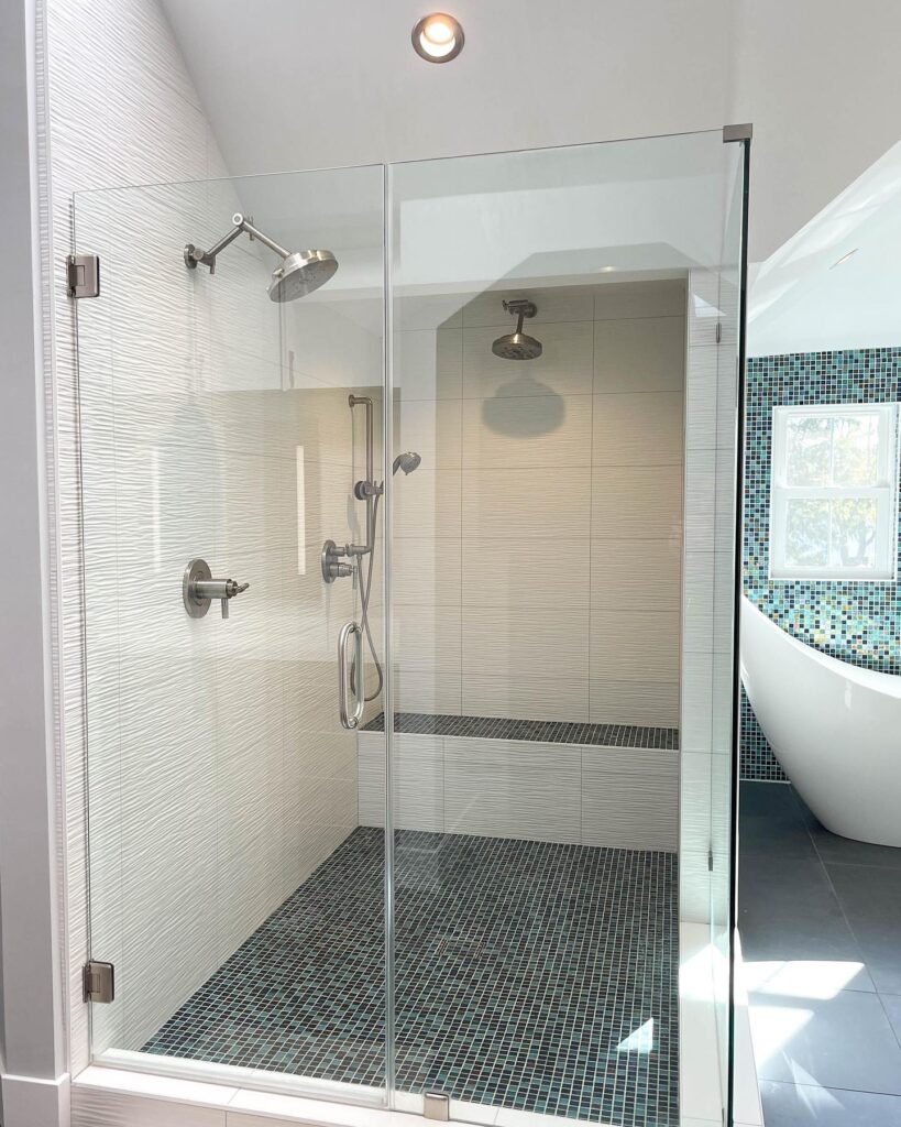 After shower remodel blue and green floor tile matches wall tile behind white tub